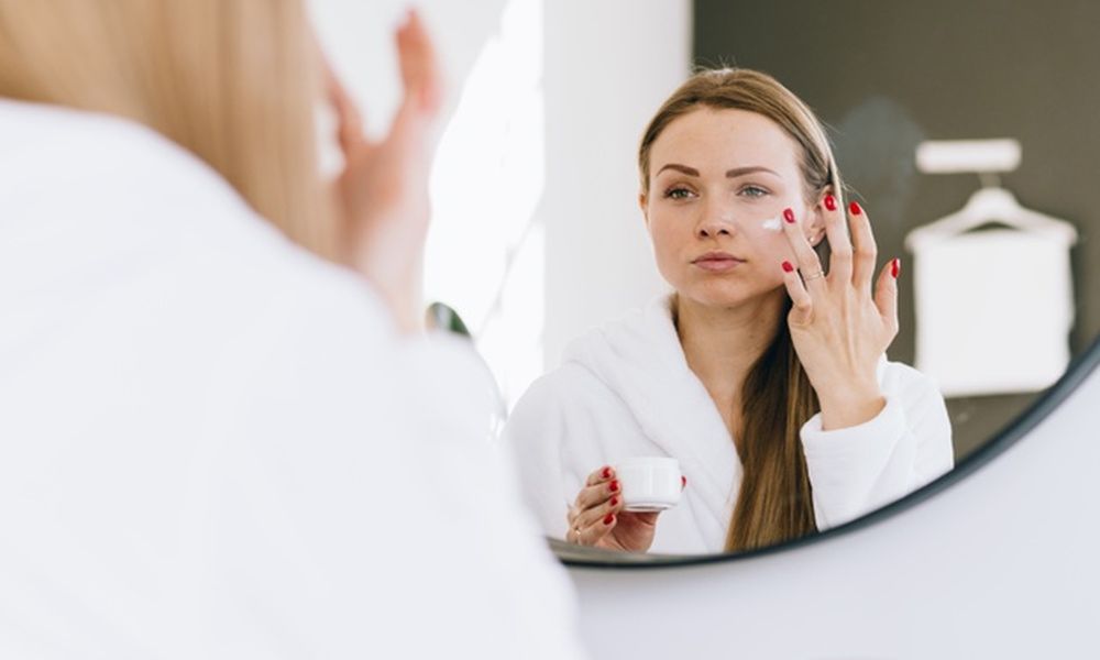 girl applying cream her face