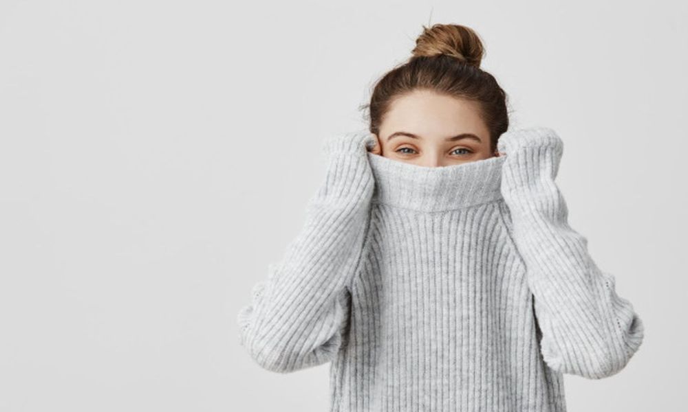 girl pulling her sweater head tied hair topknot